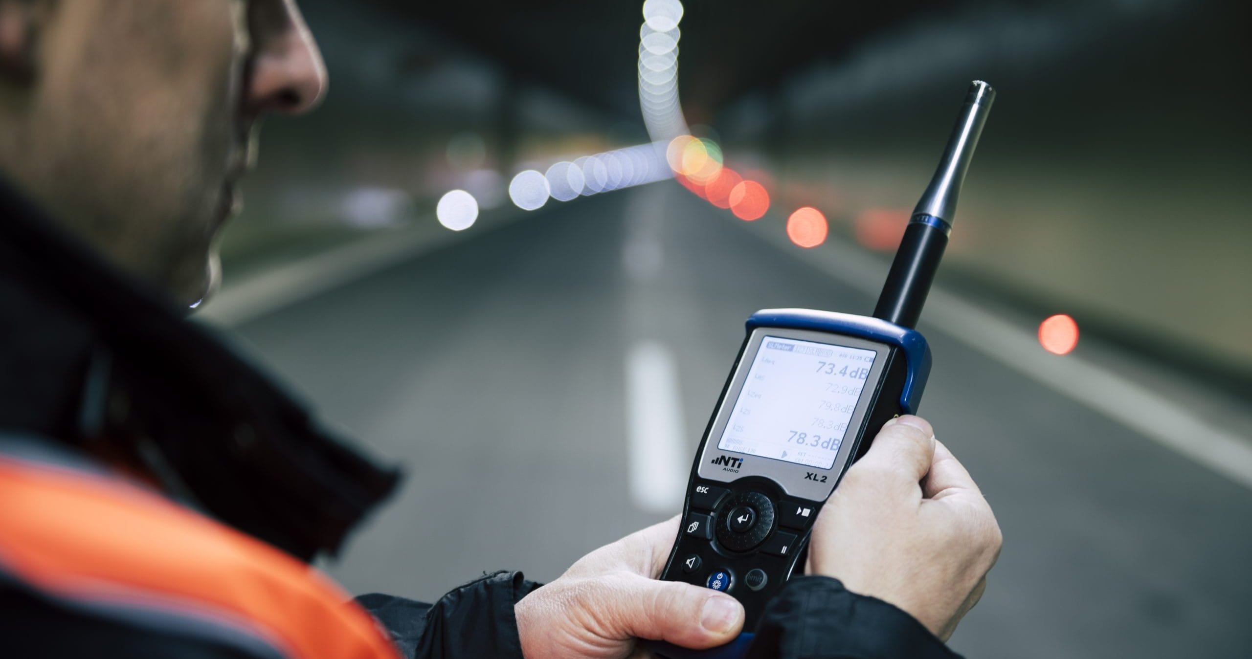 Akut: Mann in Tunnel, der ein Gerät zum akustischen Tunnelmonitoring in der Hand hält.