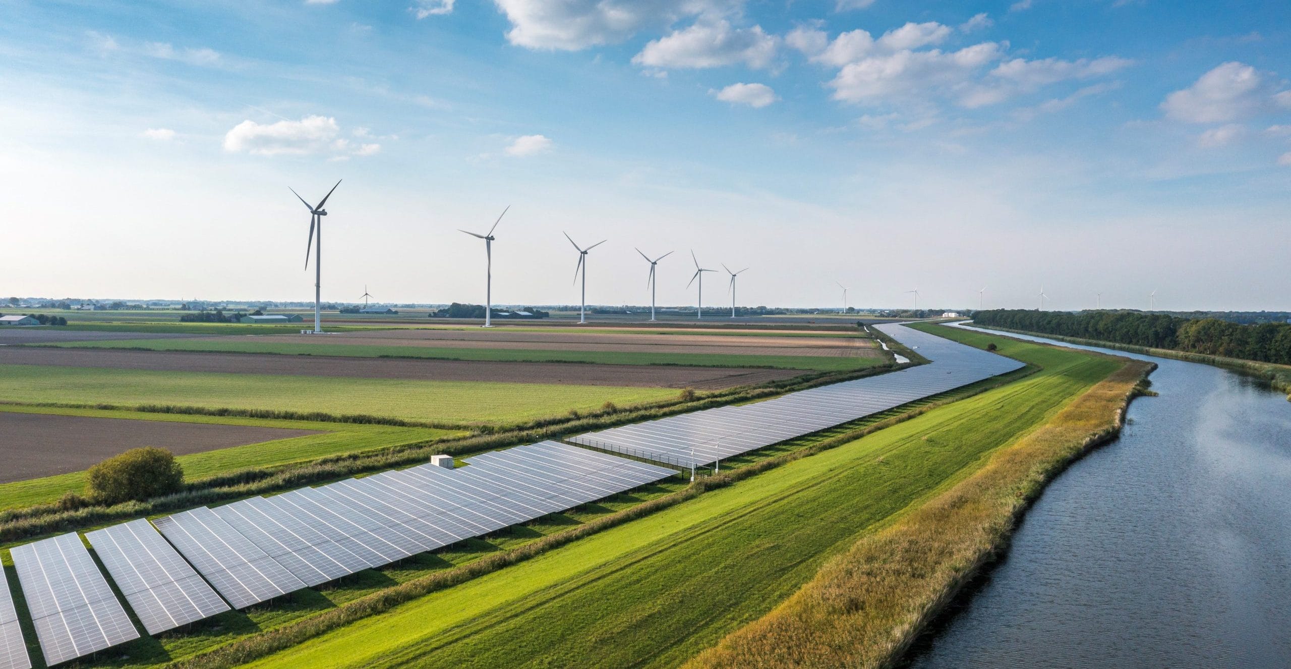 Landschaftsaufnahme mit Windrädern und Solaranlagen.