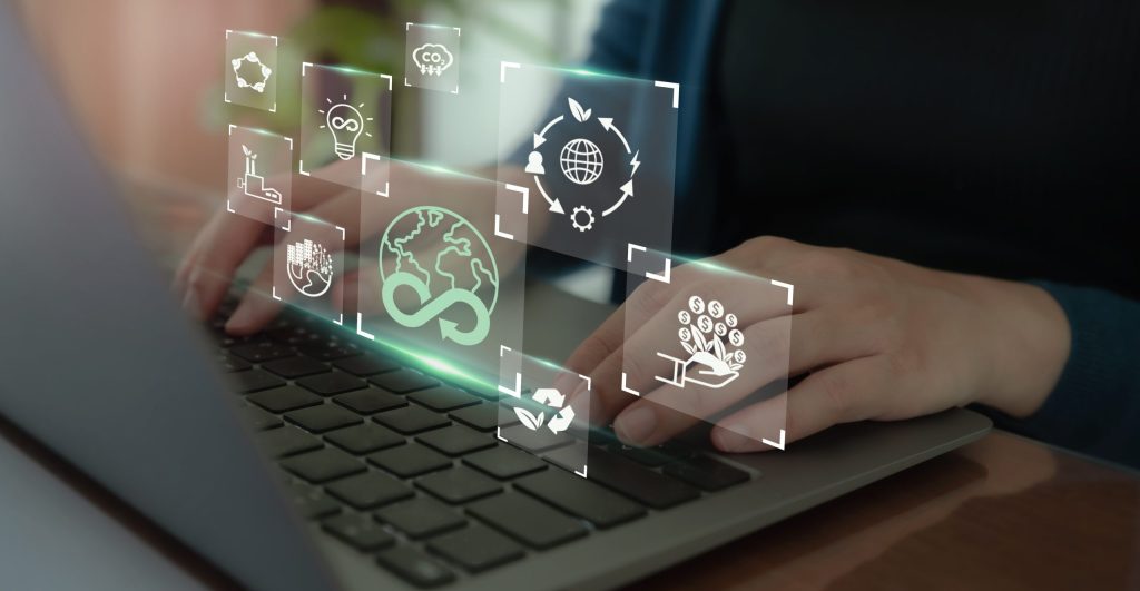 Nahaufnahme einer Person, die am Laptop arbeitet. Darüber schweben Grafiken mit diversen umweltbezogenen Symbolen.