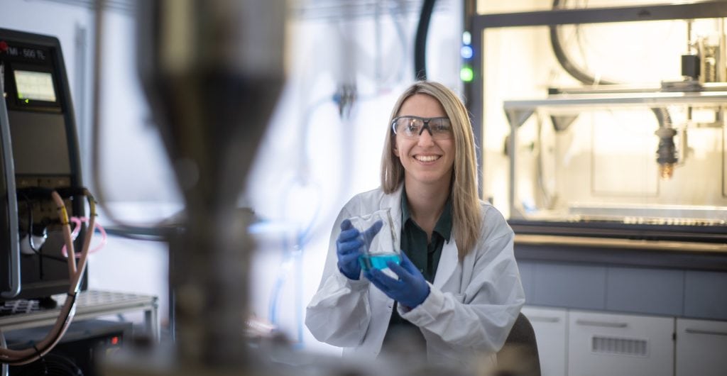Researcher at the atmospheric pressure plasma coating facility, symbol for functional coating