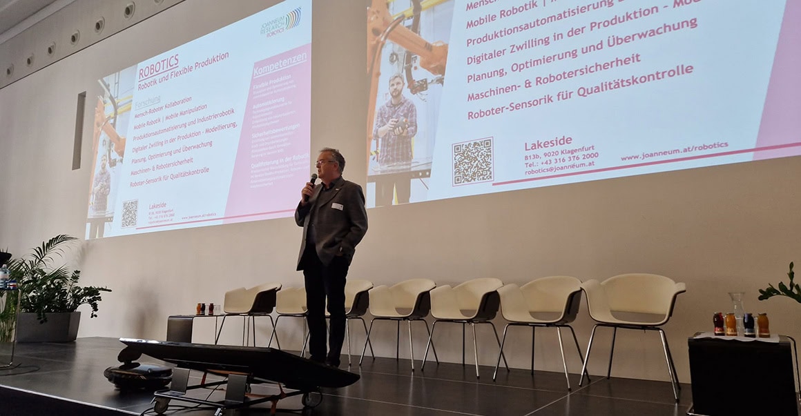 Institutsdirektor Scheibelmasser steht auf der Bühne.