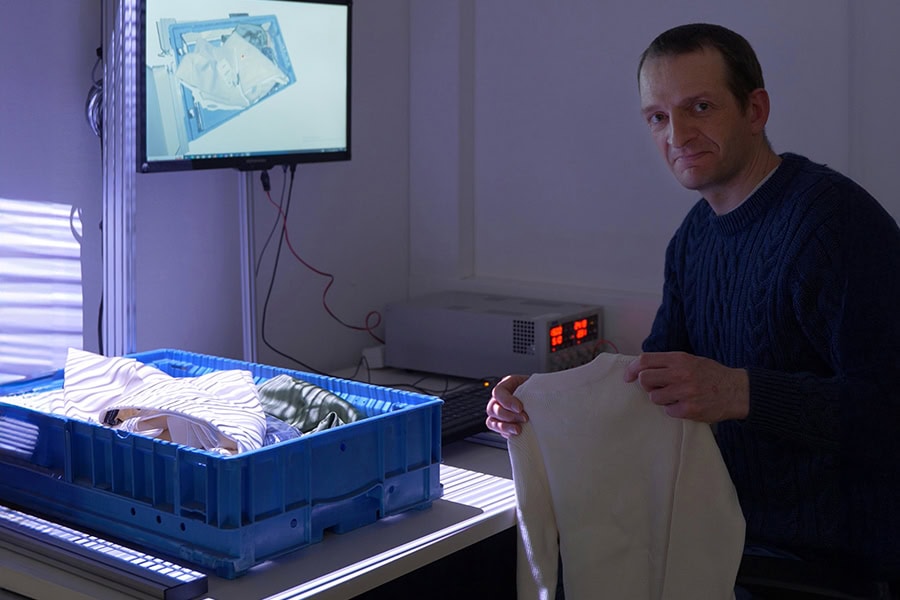 Forscher mit Kleidungsstüken vor einem Demonstartor für das Projekt CoboSort