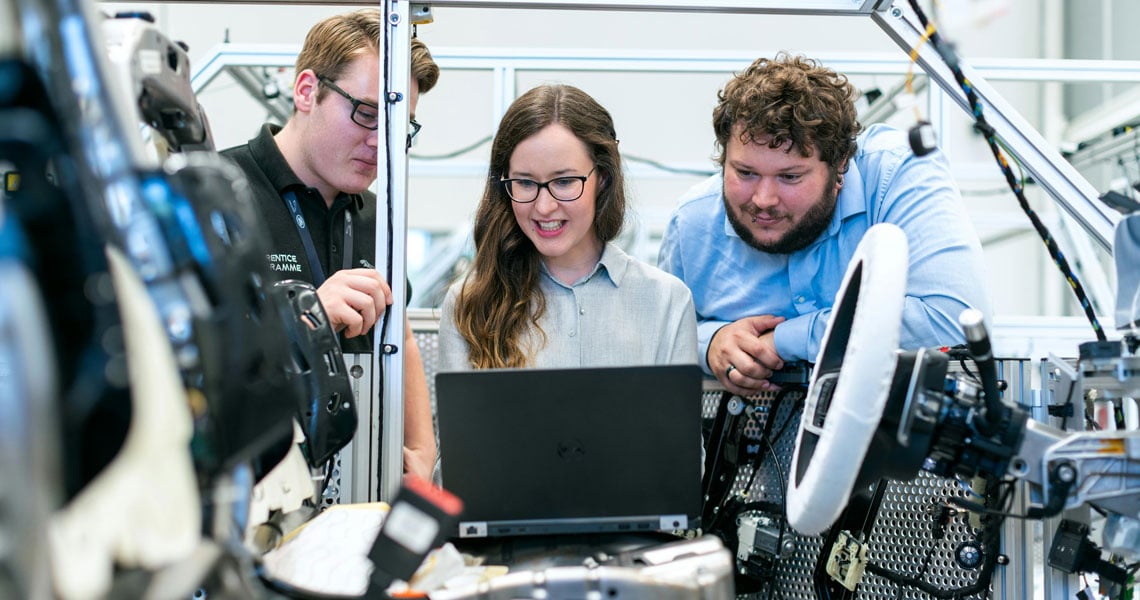 Produktionsstraße Automobilindustrie, 2 Männer, 1 Frau am Computer, Symbolbild für Projekt Fairwork